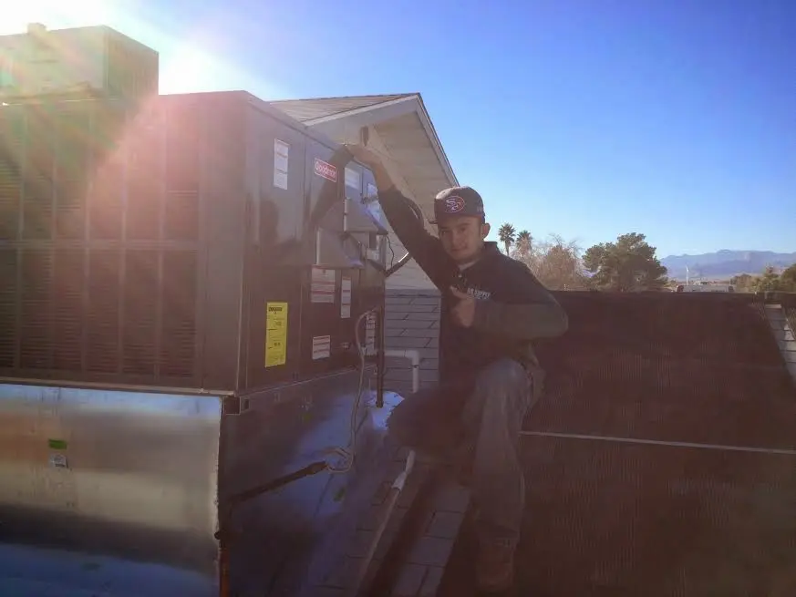 HVAC technician performing Boiler Repair on a rooftop unit in Burien